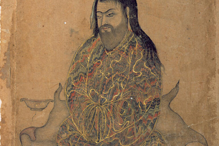 bearded, long-haired man man seated, weraing robe