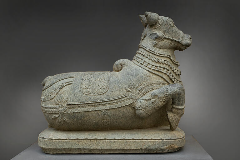 stone carved bull, lying down, back to viewer