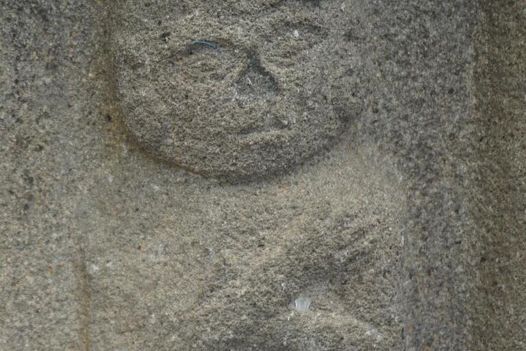 bas-relief stone carving, seated figure, arms crossed, wearing crown of some sort