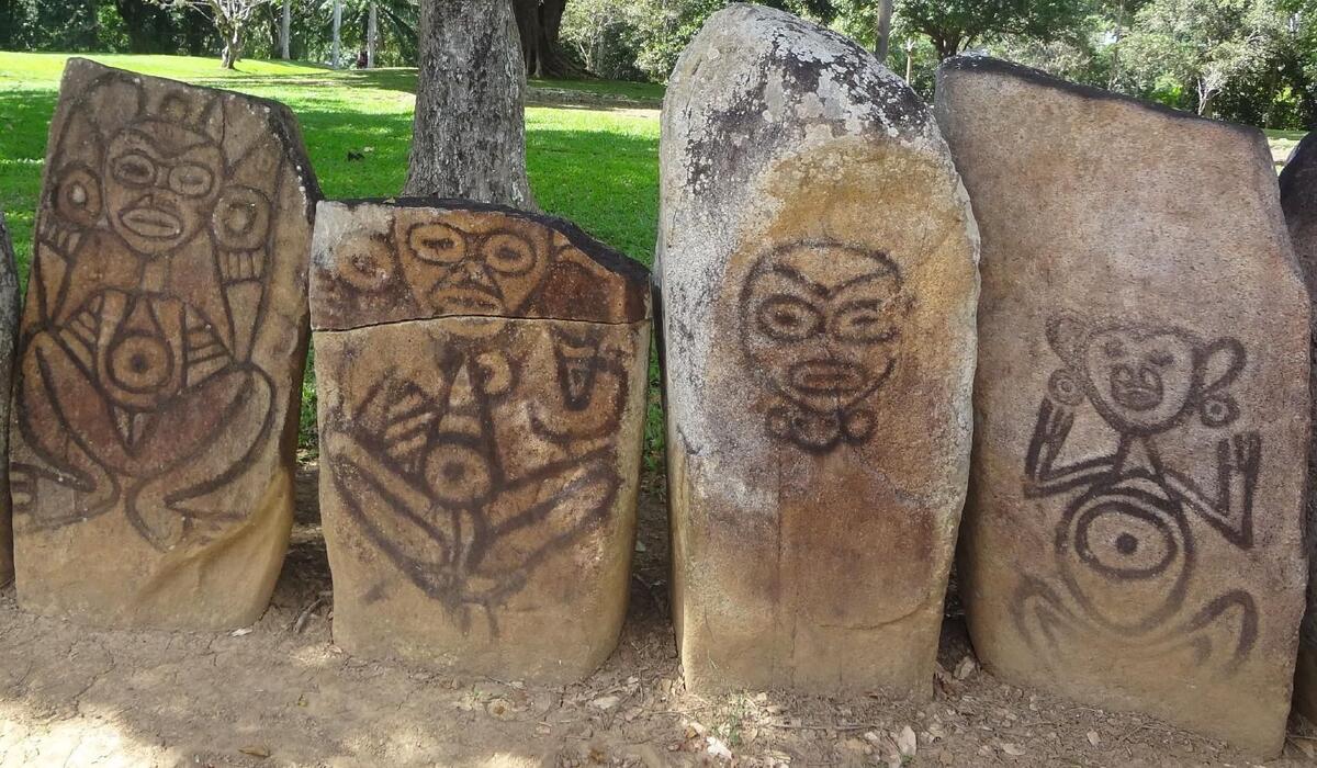 Four large stones with petroglyphs of stylized images of people.