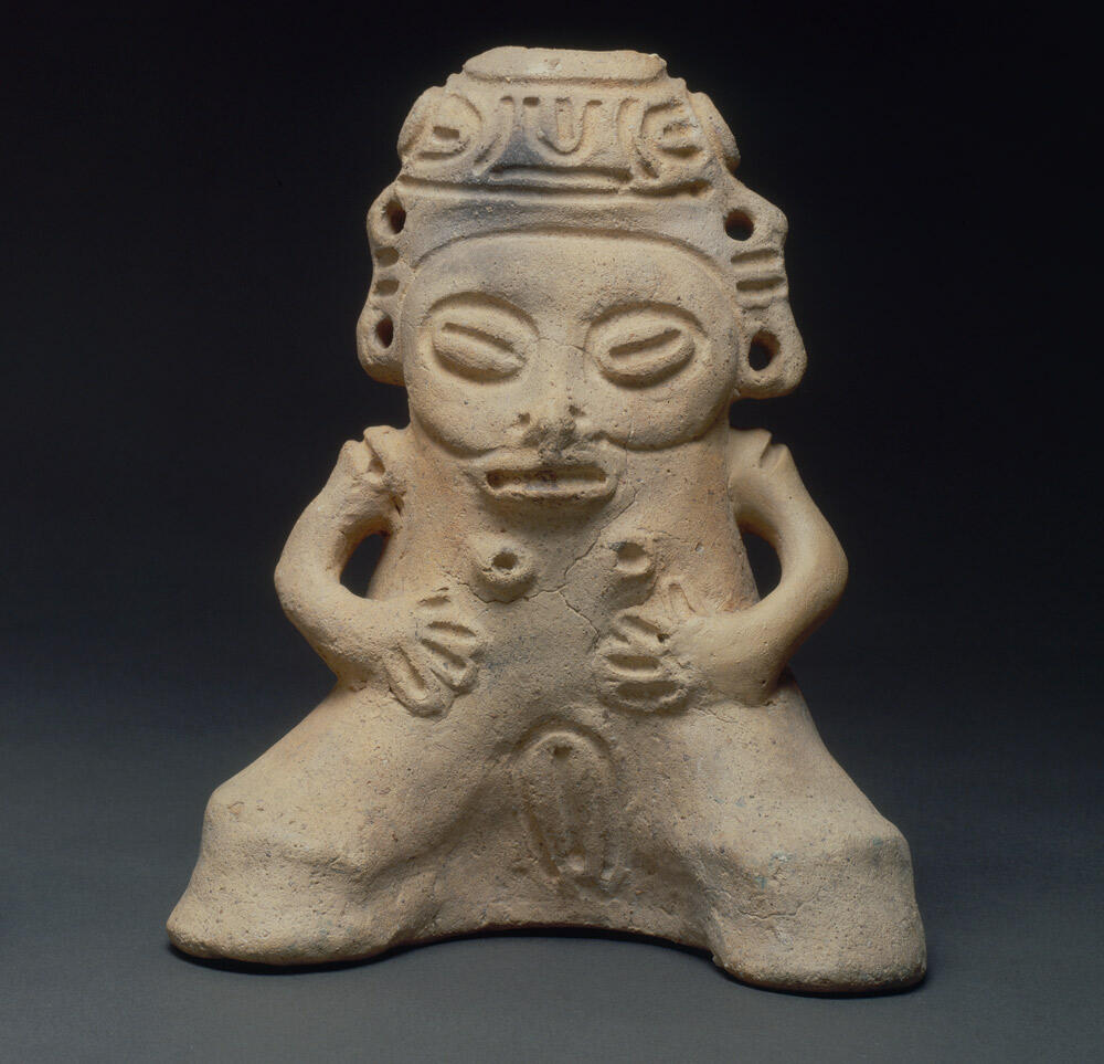ceramic female figure with face, arms and legs, plus breasts and vulva