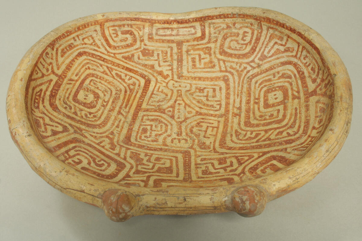Oval dish with geometric design that looks like a series of coiled snakes.