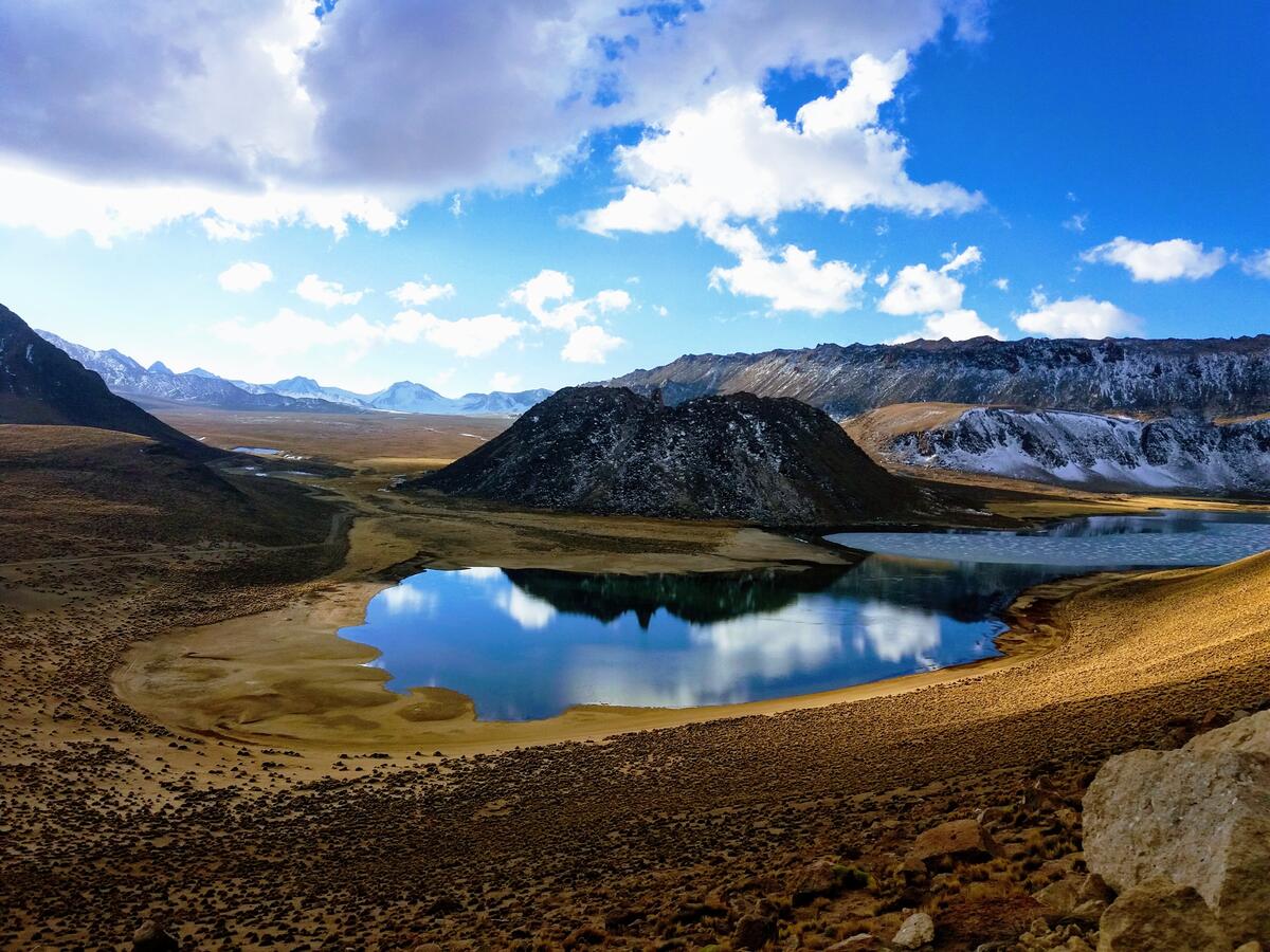 mountains with reflective lake surface and clouds