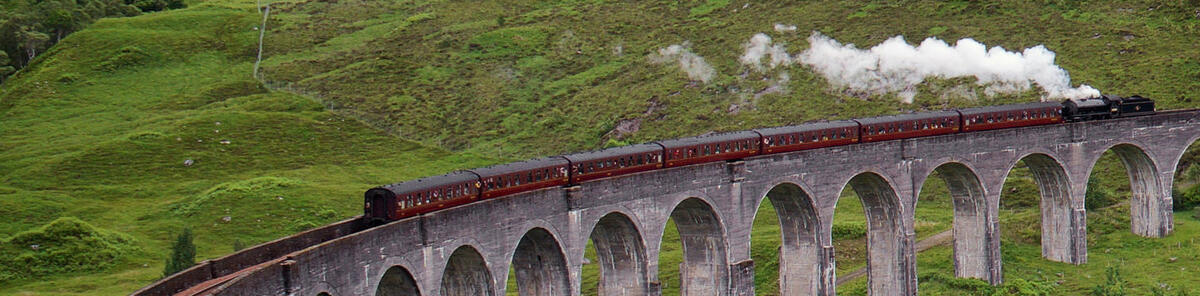 Steam train crossing a stone bridge