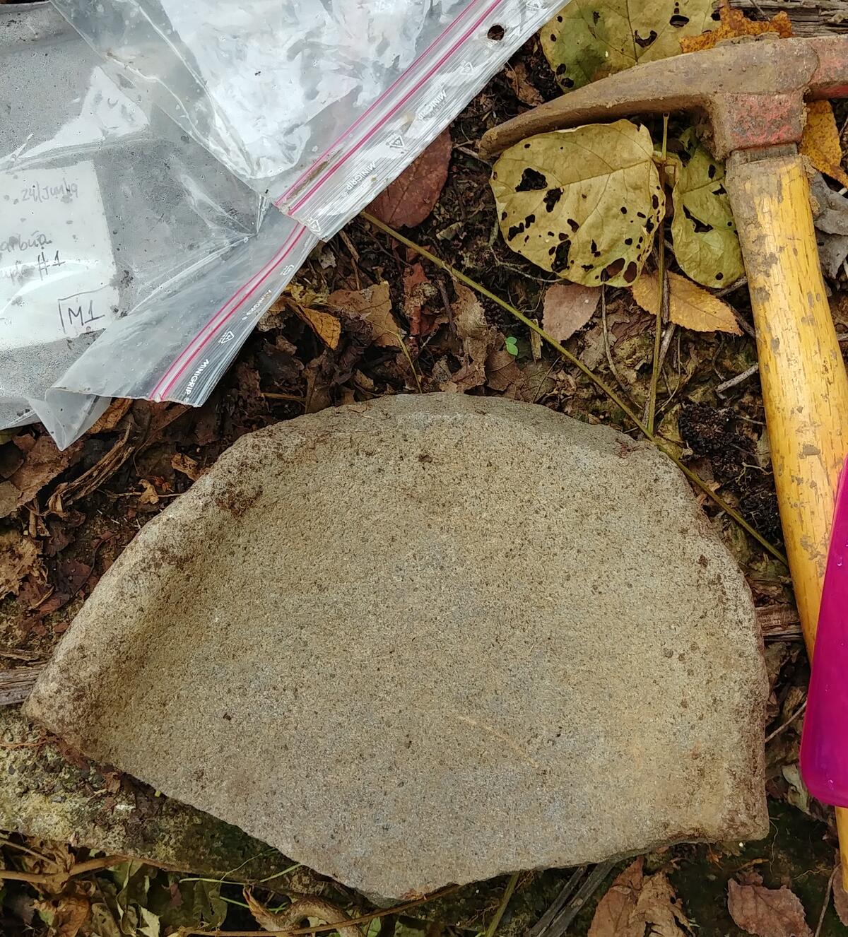 flat stone in half-circle shape, hammer-shaped object, plastic bags