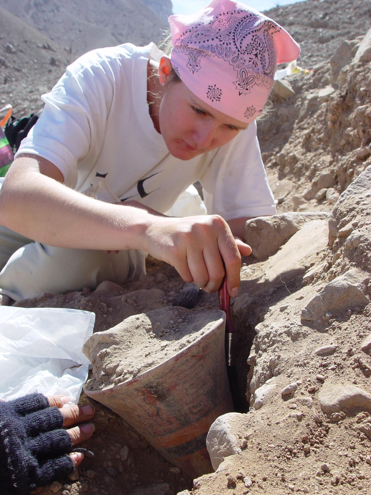 close-up of woman's face, intently looking at her work on a dig